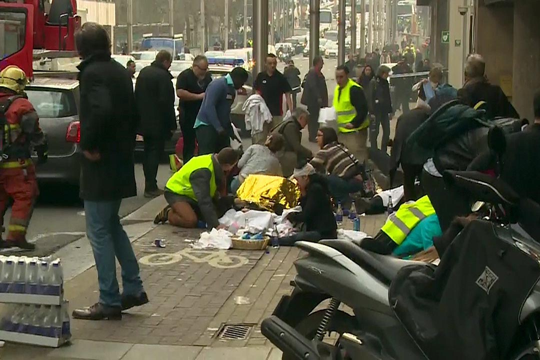 2016年3月22日,比利时布鲁塞尔马尔比克(Maelbeek)地铁站发生爆炸后,救援人员在地铁站外照护伤者。摄:RTL Belgium via Reuters