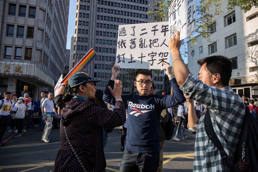 11月17日,「下一代幸福聯盟」號召上萬人包圍立法院,聲援同志的人舉牌被阻擋在外。