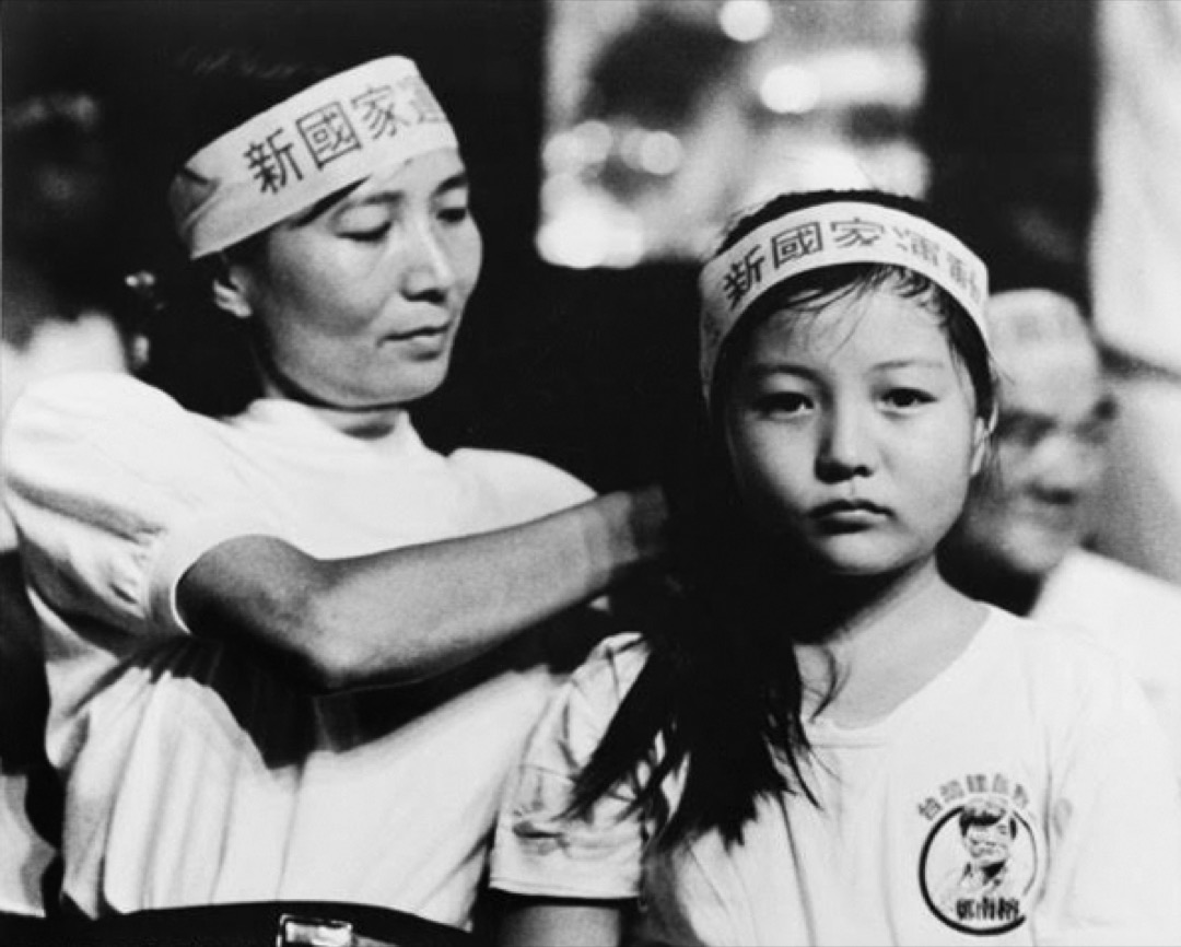 鄭南榕於1989年4月7日自焚身亡後,他的遺孀葉菊蘭於同年底宣佈參選立法委員,訴求「請你陪我打一場母親的戰爭」,葉菊蘭從此踏入台灣政壇。圖為葉菊蘭在街頭替時年9歲的女兒鄭竹梅整理頭髮、繫上頭巾。