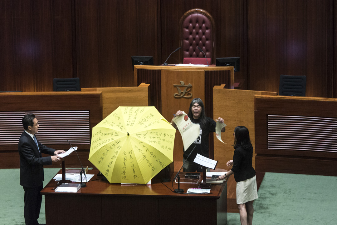 2016年10月12日,香港立法会议员梁国雄于宣誓时,手持黄色雨伞并撕毁一张代表人大831决议的道具。