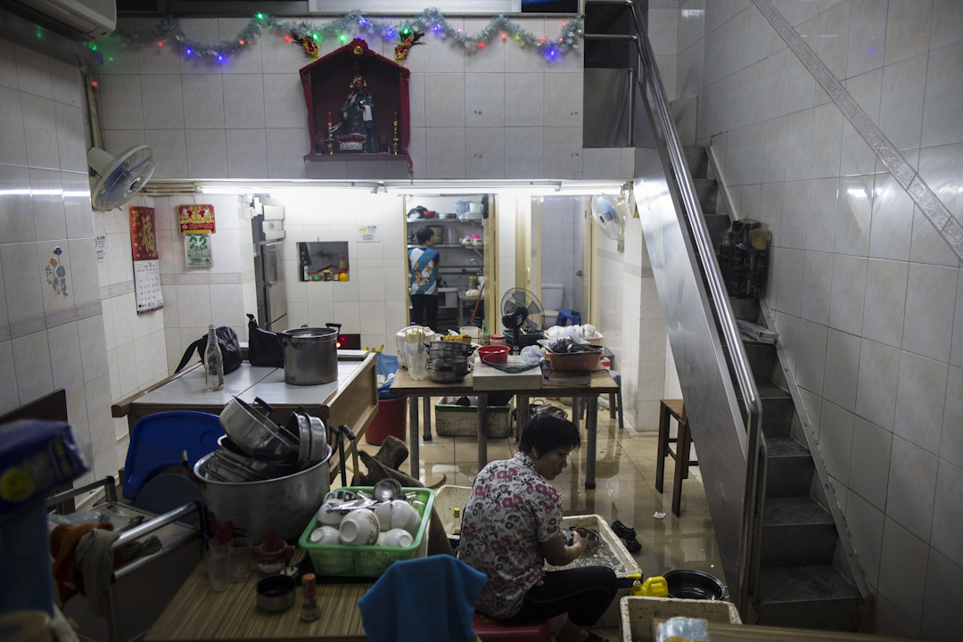 澳門遭颱風「天鴿」吹襲,多區出現嚴重水浸,一間店舖的居民正在清理積水及執拾。
