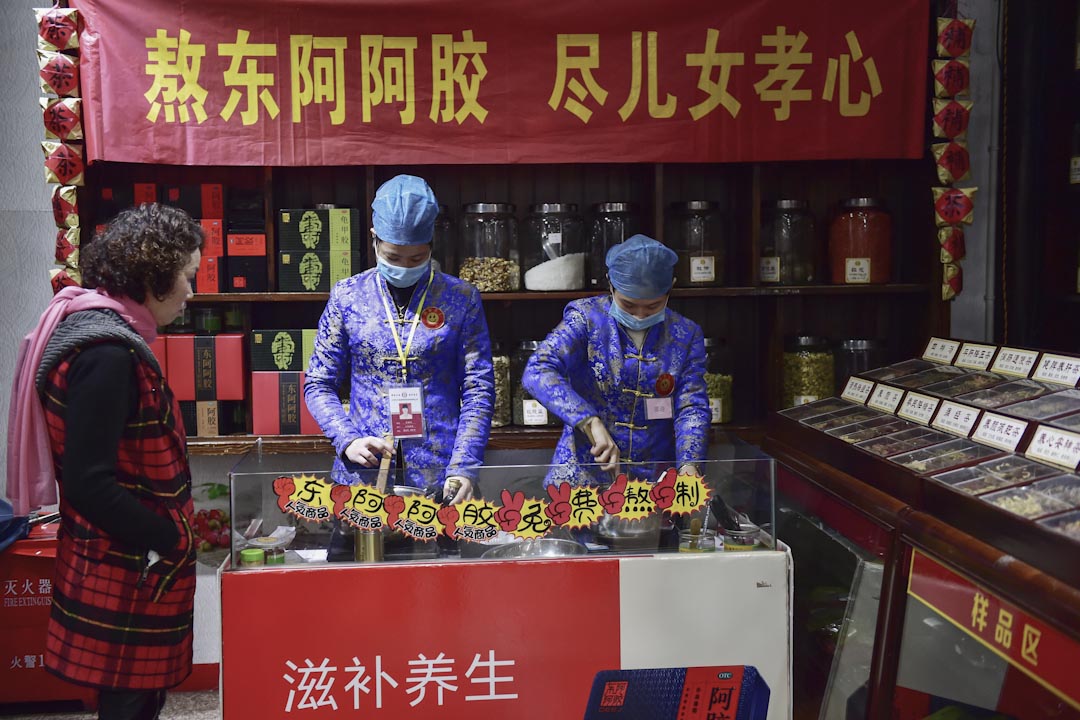 浙江省義烏的三溪堂國藥館,兩名工作人員示範熬製阿膠。