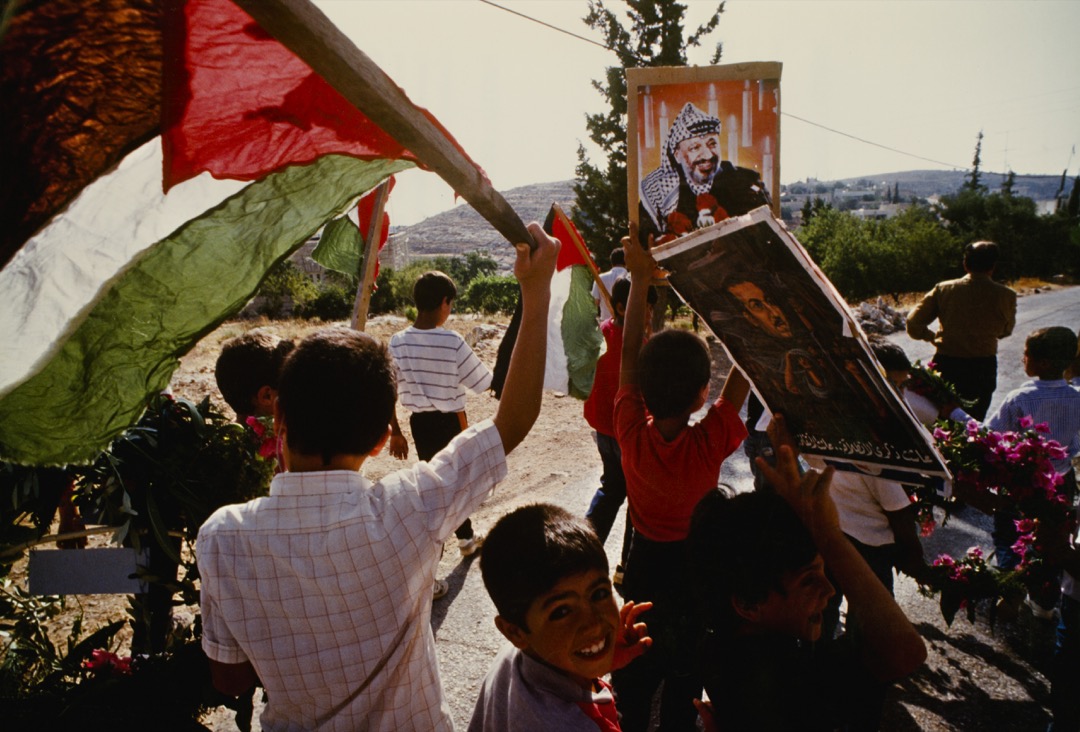 1989年6月,在巴勒斯坦被占的土地上,巴勒斯坦儿童举标语和旗帜表示支持巴解组织领导人阿拉法特。