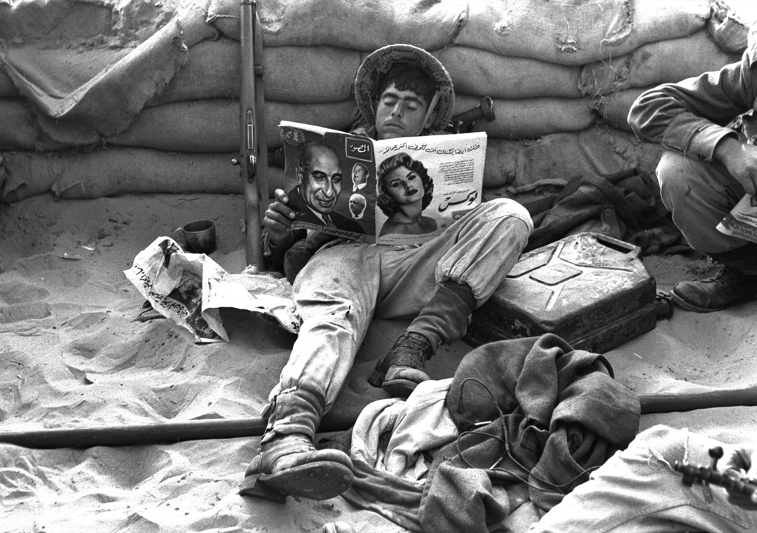 1956年11月,时值第二次中东战争,以色列第一次占领苏伊士运河地区时,一名以色列士兵阅读在被占领的埃及阵地中找到的阿拉伯语杂志。