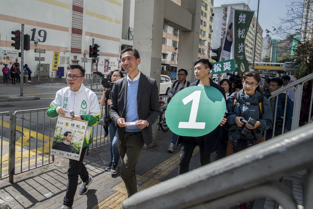 民协在“南山、大坑东、大坑西”为姚拉票、过票，效果不佳的背后，似乎另有一番故事，牵出深厚的社区居民关系问题。图为2018年3月11日，姚松炎由民协区议员何启明陪同下，在石峡民街上派单张进行拉票活动。