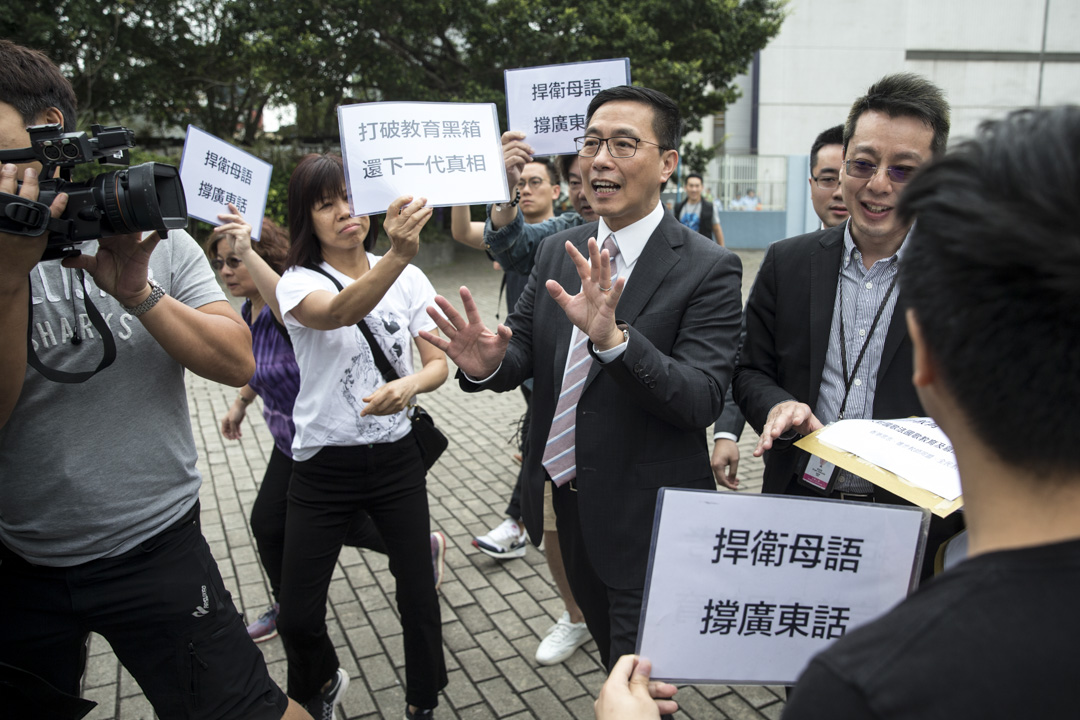 2018年5月4日,教育局局长杨润雄到一间中学出席活动前,与香港众志的秘书长黄之锋等人对话,并接收请愿信。杨润雄指并无打算改变两文三语的政策。摄:端传媒