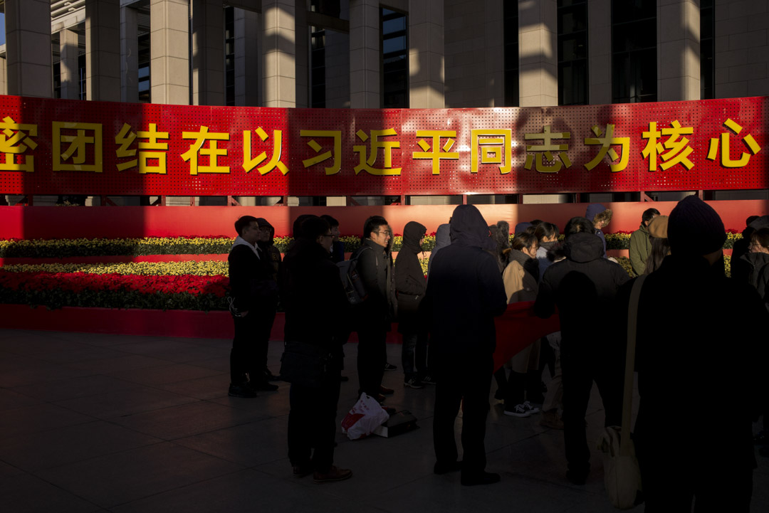「偉大的變革─慶祝改革開放40周年大型展覽」在北京的國家博物館舉行,大門前有巨大標語,參觀者手持共產黨旗拍照。