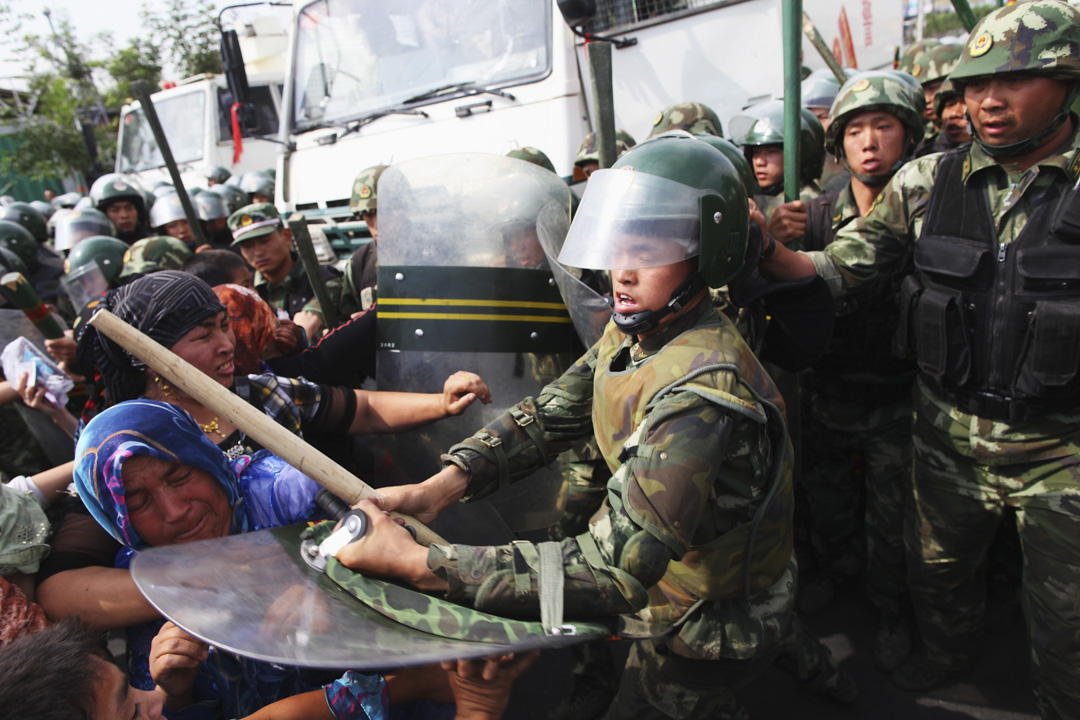 2009年7月7日,新疆烏魯木齊,維吾爾族婦女於街頭抗議後遭軍警驅趕。