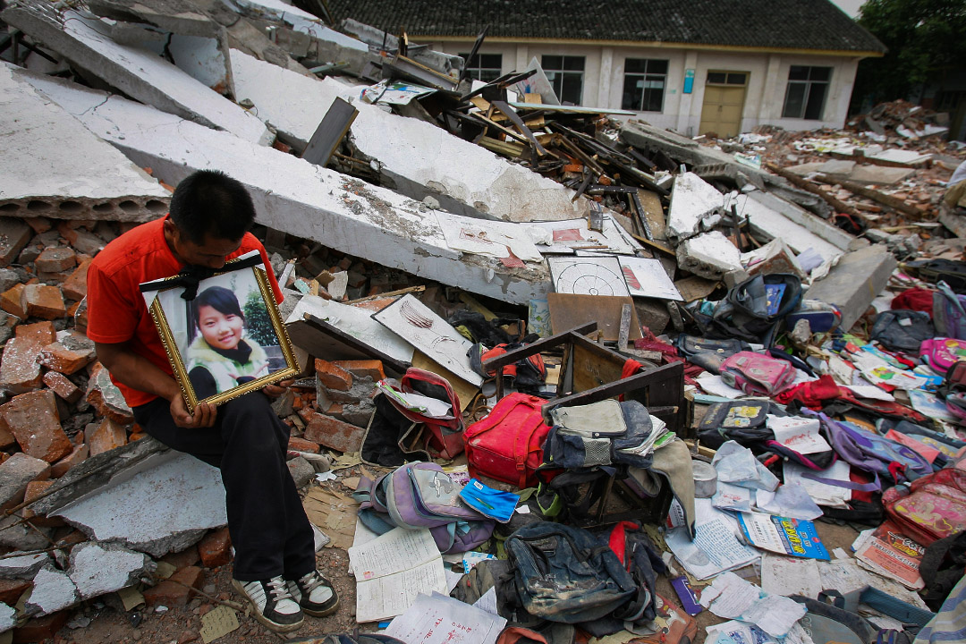 2008年5月20日，四川省綿竹市的學校，一名父親參加一場哀悼和抗議活動，其女兒在地震因校舍倒塌而壓死。