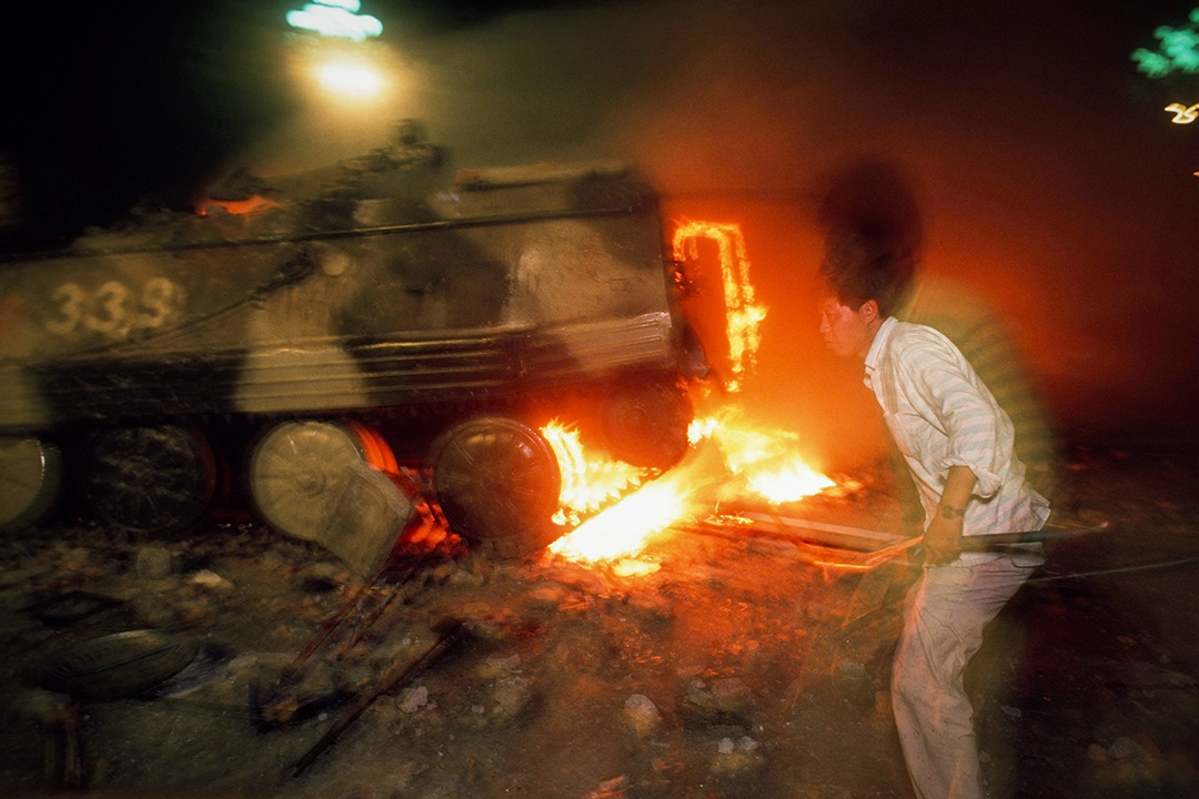 1989年6月4日,一名示威者与一辆燃烧的装甲运兵车。摄:Peter Charlesworth/LightRocket via Getty Images
