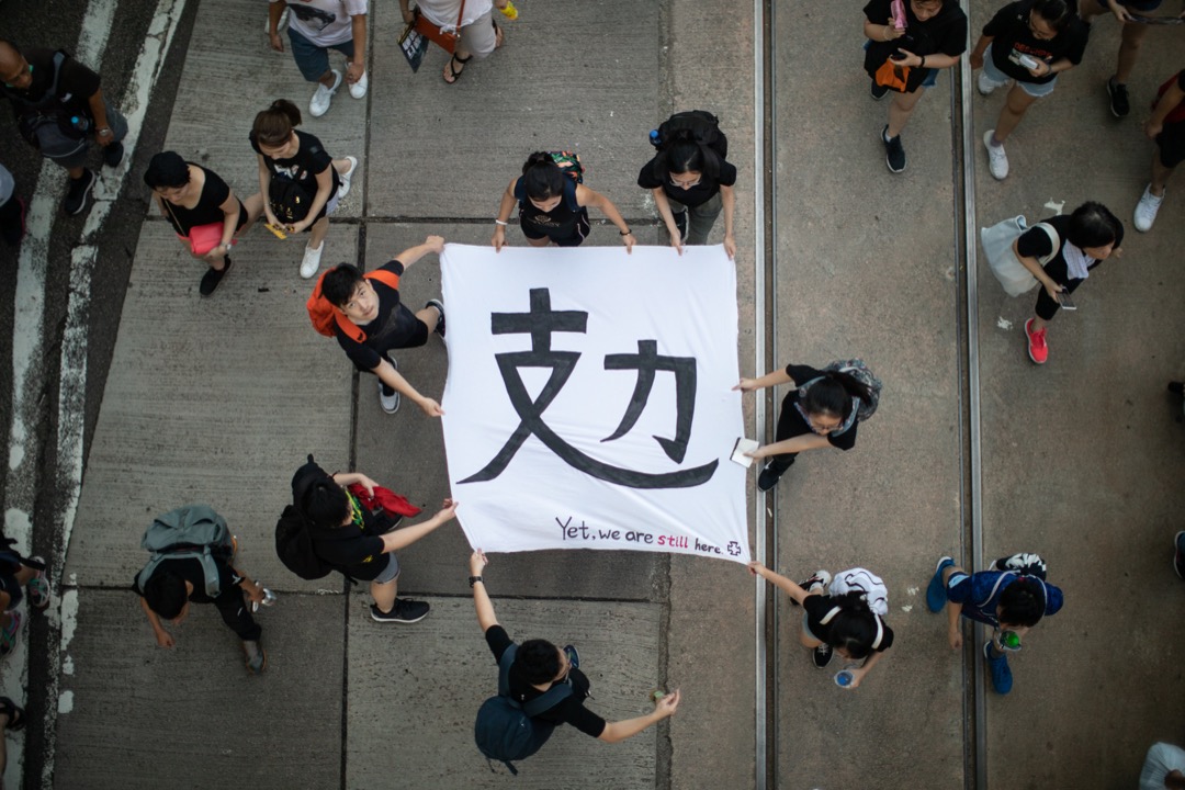 2019年7月1日,民阵发起七一大游行,有参加者拿著写有“攰”字的横幅。