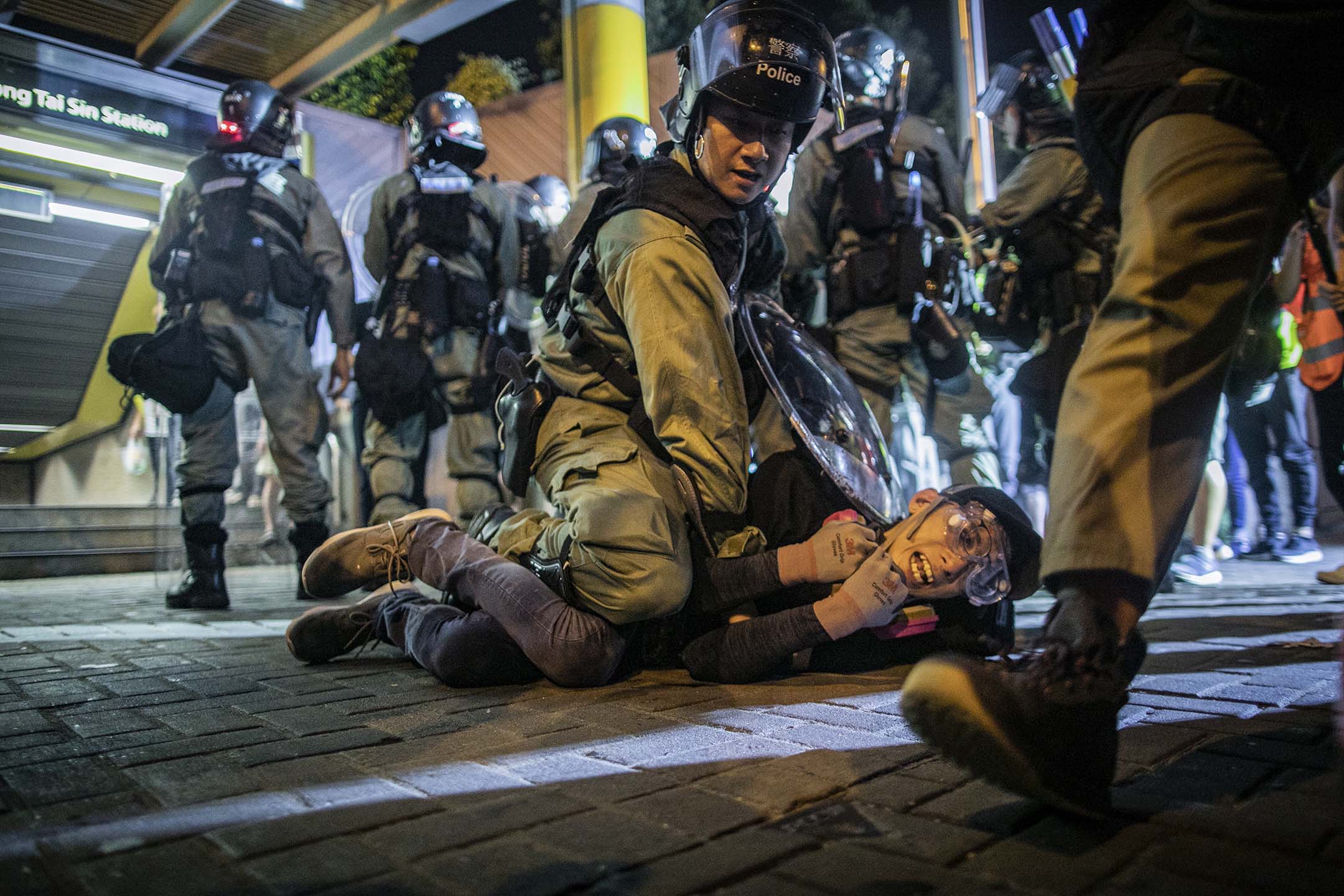 2019年8月24日,一名警員在黃大仙制服一名反修例運動示威者。攝:陳焯煇/端傳媒