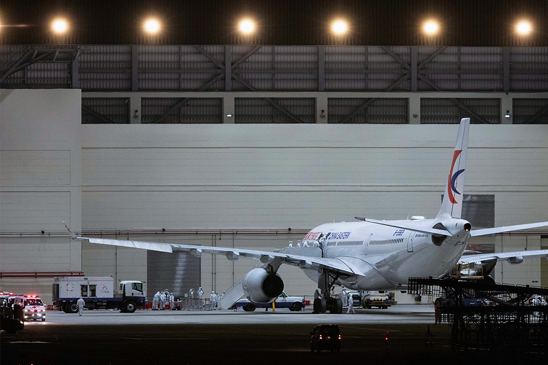 2020年2月3日桃園國際機場,武漢台商午夜抵達機場,飛機直接進入維修棚,醫護人員上機檢疫後安置隔離。