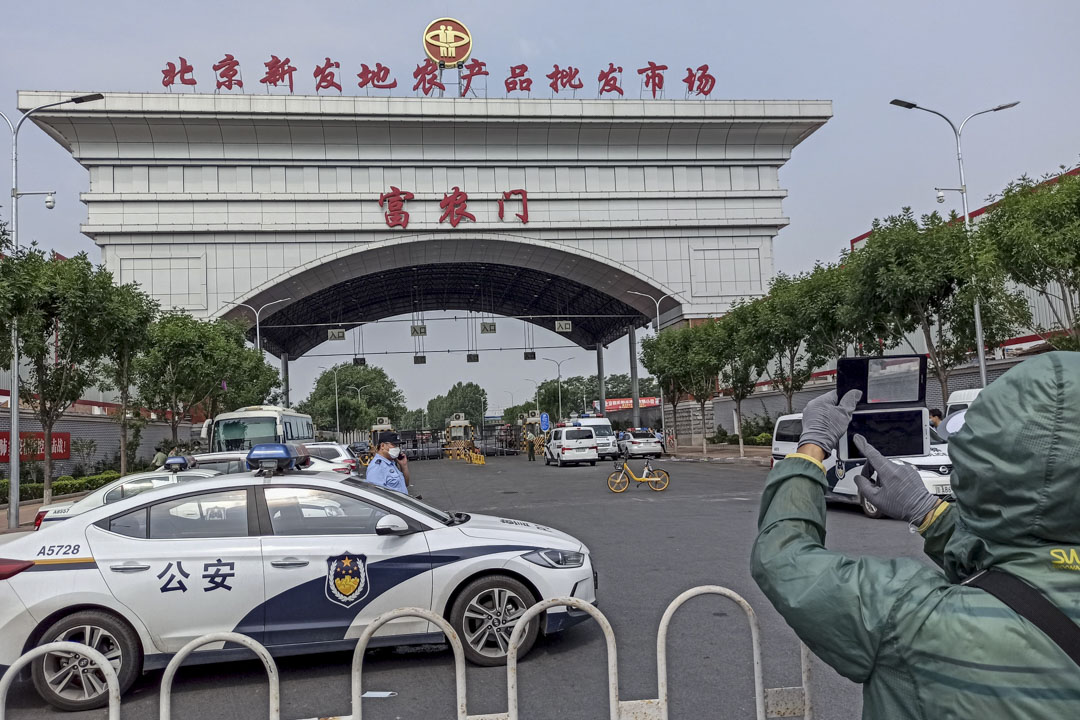 2020年6月13日北京，警察守衛在封鎖的新發地市場的入口。