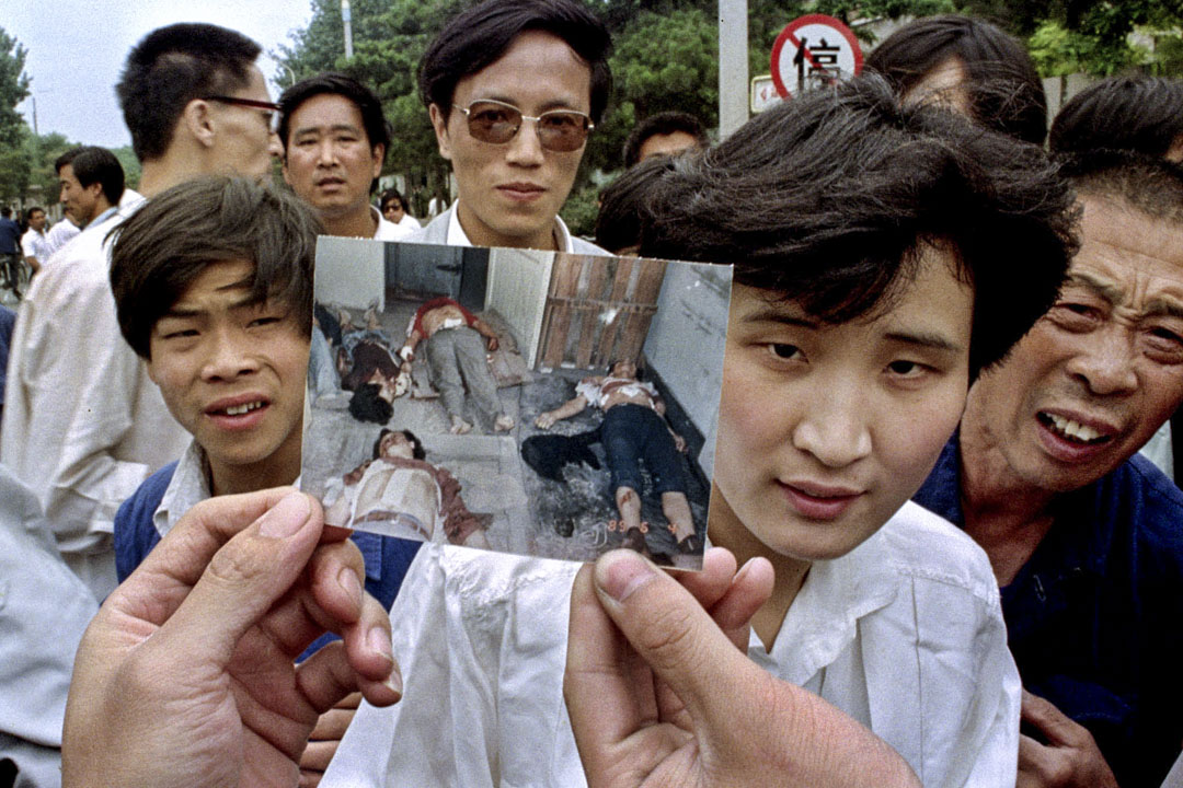1989年6月5日北京,人们举著一张照片称他们是天安门广场上被镇压的死难者。