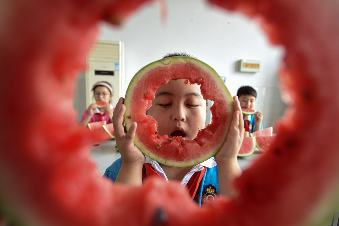 2020年8月7日中国江苏省,学童一起吃西瓜。