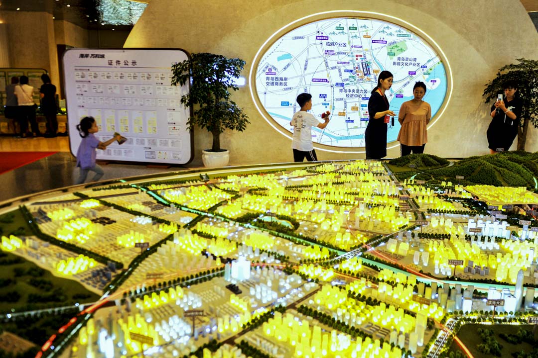 2020年7月19日,山东青岛市一家房地产销售大厅,销售员向顾客推销楼盘。