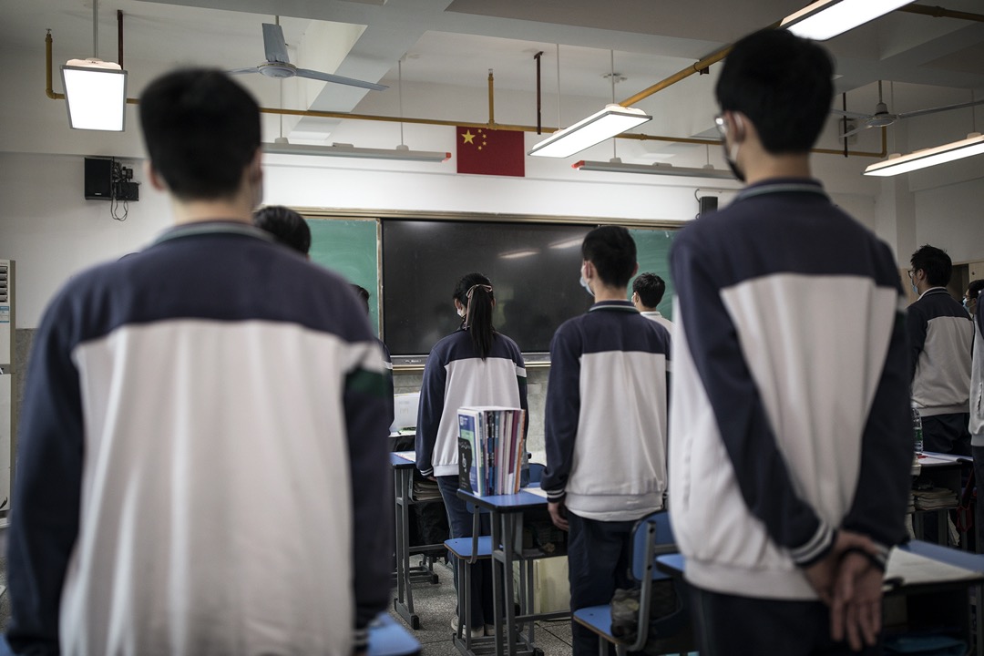 武汉一所学校,学生对著国旗起立。