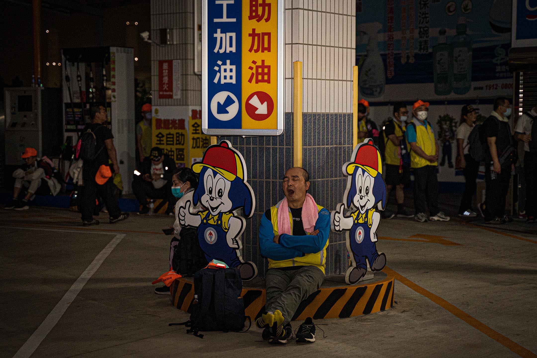 在少有民宅的公路路段上,加油站是信眾如廁、補給、休息的重要據點。一名信眾在加油站就地休息。