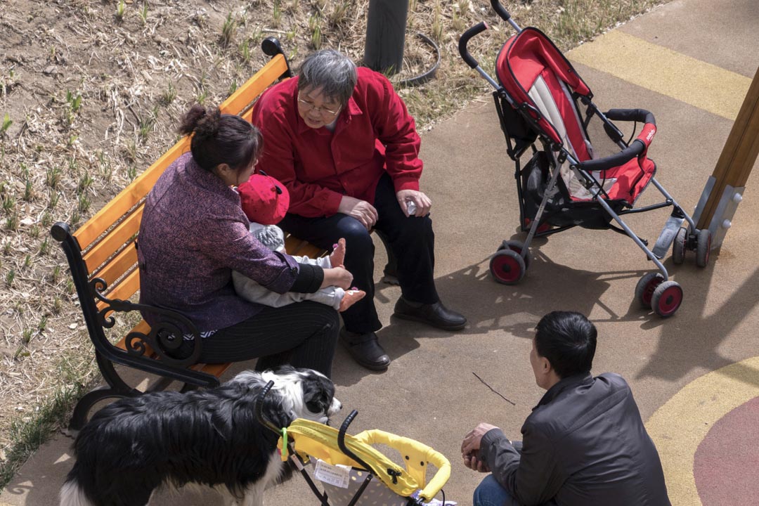2018年3月9日,老人在一個小花園裡照顧一個新生嬰兒。