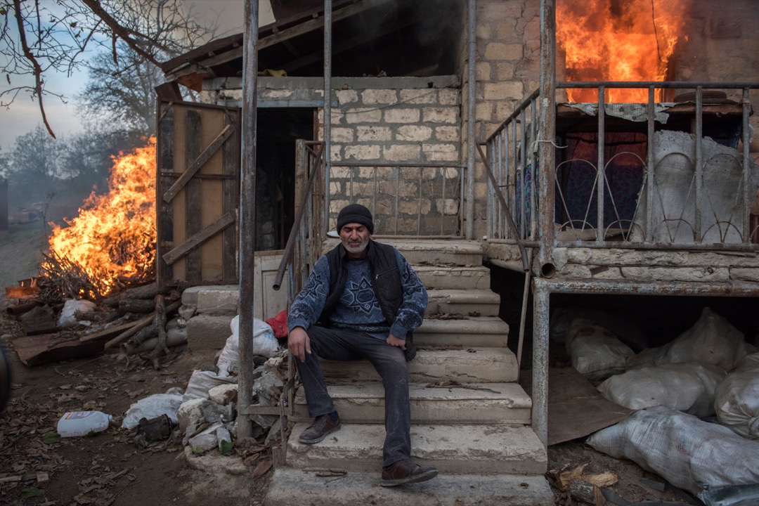 2020年11月25日,納戈爾諾-卡拉巴赫(Nagorno-Karabakh)小鎮 Karegakh,男子 Areg 坐在一所正在燃燒的建築物前。