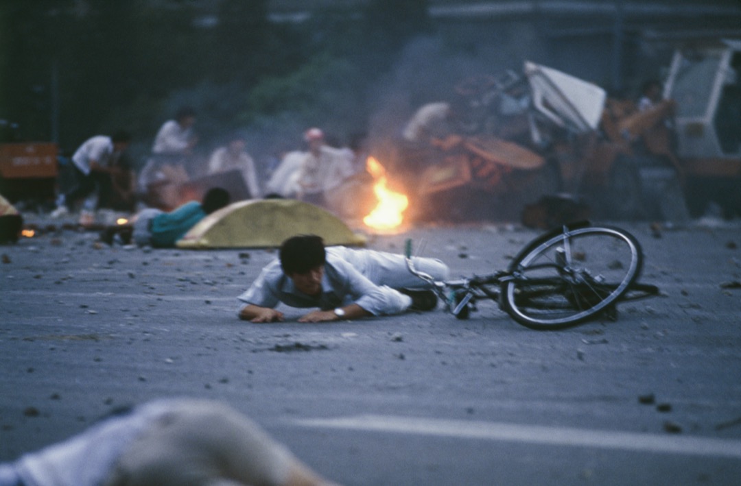 1989年6月4日凌晨,北京,解放军在天安门广场一带向市民开枪,有市民趴在地上躲避。