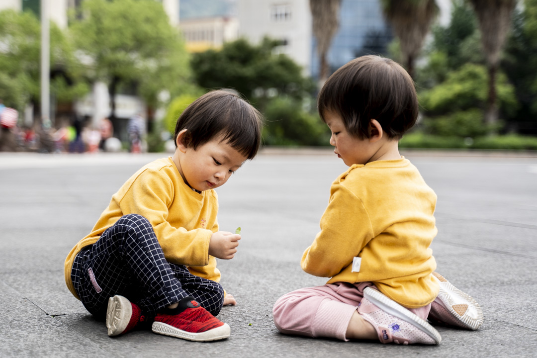 2021年5月25日,浙江青田火车站广场,一对双胞胎姊妹在玩耍。摄:林文清/端传媒