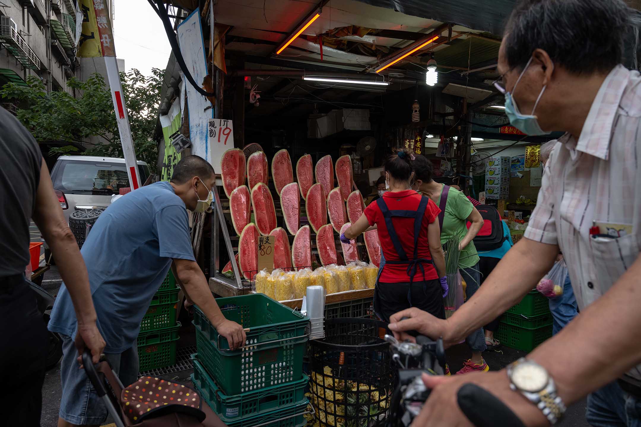 2021年5月27日台灣台北,戴著口罩的人們在市場上購買食物。