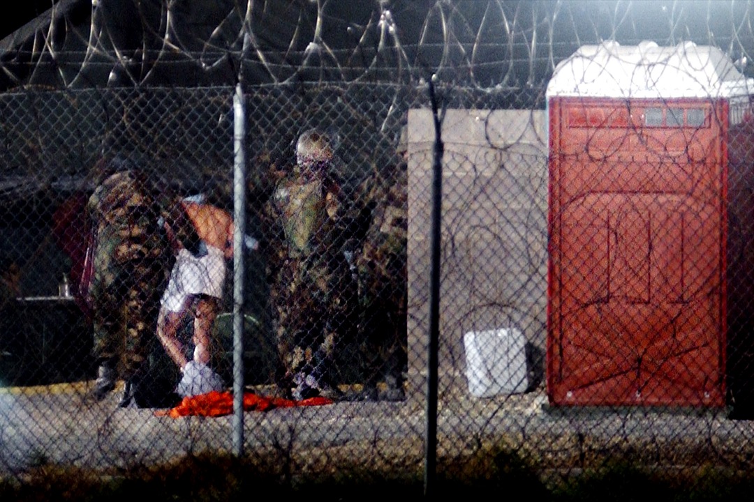 2002年2月7日,28名被拘押者送抵美軍在古巴設立的關塔那摩灣拘押中心。其中,被俘虜的塔利班武裝組織成員將被美國政府視為戰俘,其權利受日內瓦公約所保護,但其他懷疑恐怖組織成員如阿爾蓋達戰士講不會受到同樣對待。
