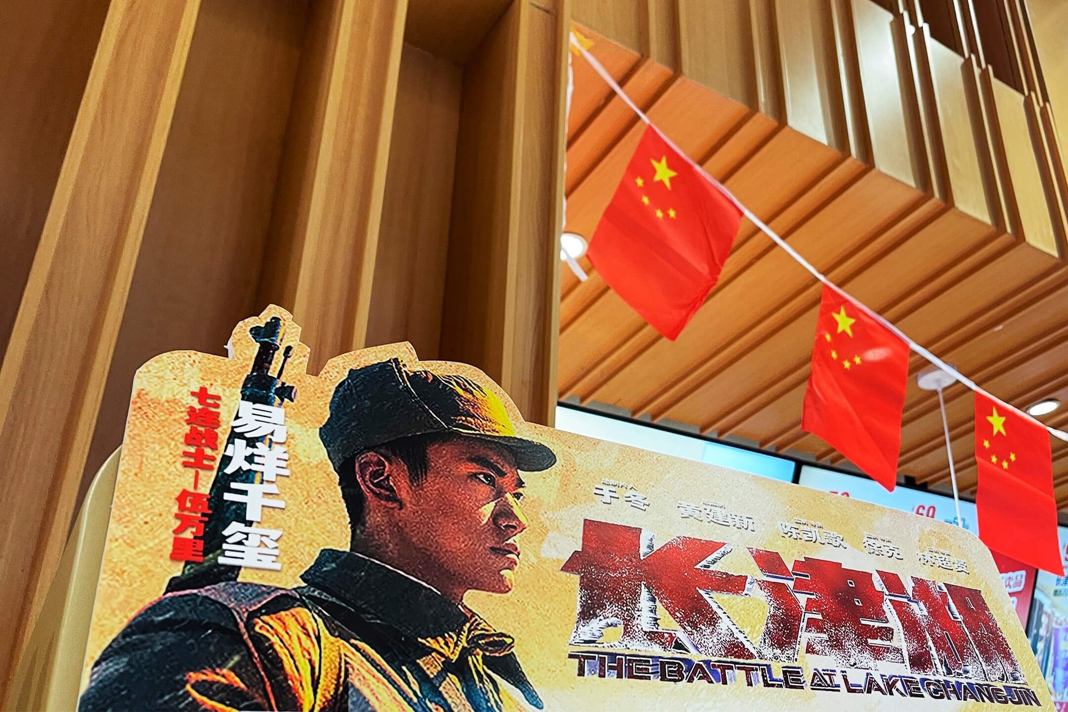 2021年9月30日，中國首都北京一家戲院門外，擺放著《長津湖》的電影海報，門口懸掛著國旗裝飾迎接國慶。