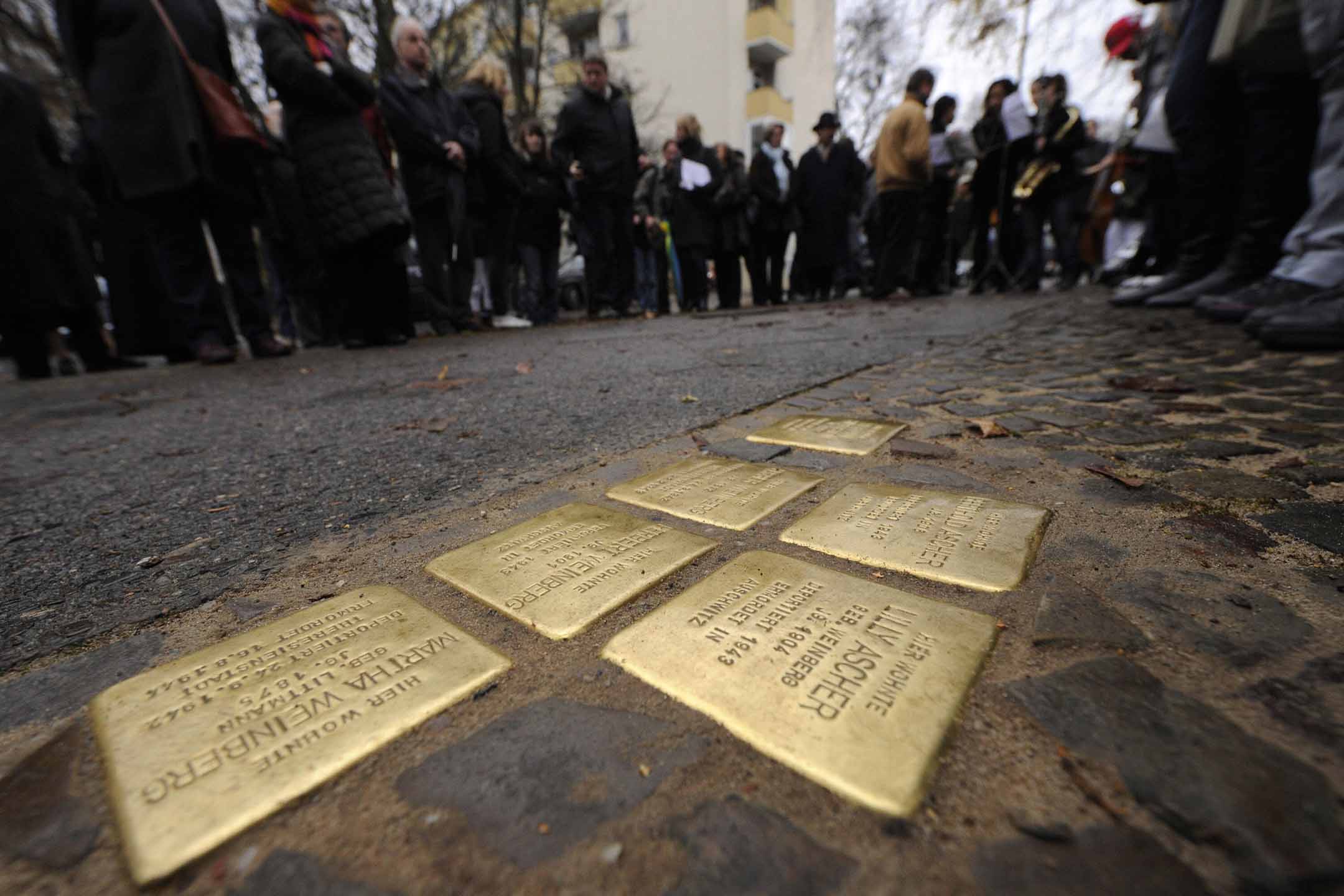 2008年11月26日柏林克羅伊茨貝格區,人們站在“絆腳石”(Stolpersteine)周圍。