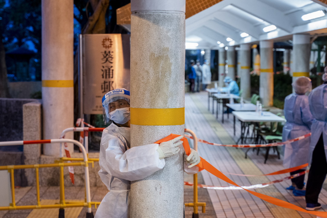 2022年1月26日,葵涌邨一個穿上保護衣的工作人員把守夏葵樓的出入口。