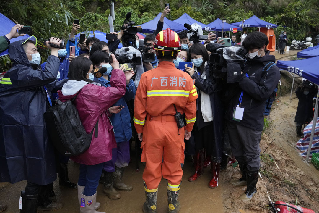 2022年3月24日，中國西南部廣西省莫埌村，一名救援隊成員在墜機現場向媒體介紹情況。