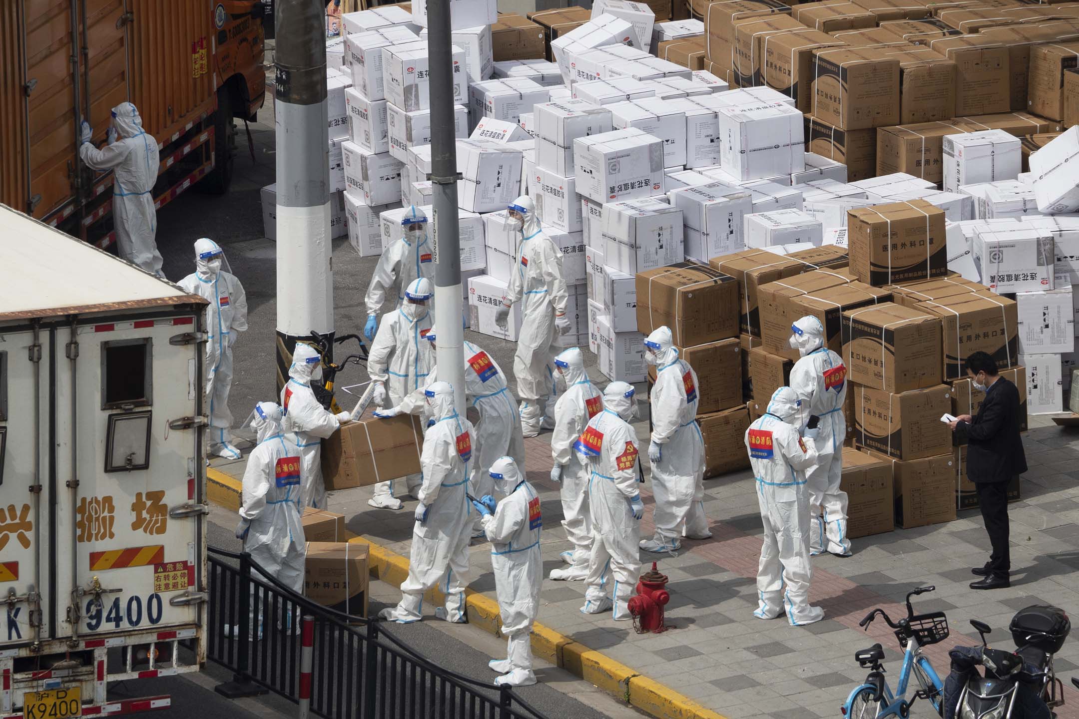 2022年4月10日,中國上海 ,志願者和工作人員於街道卸下口罩和中藥等醫療用品。