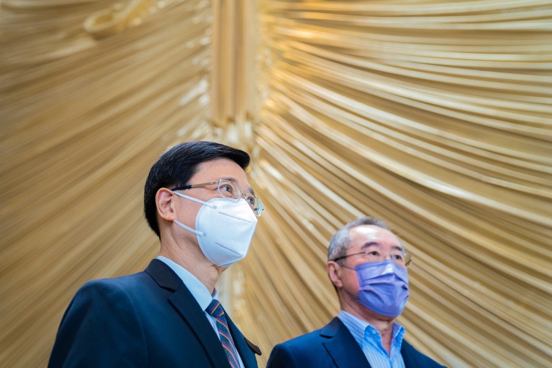 2022年4月11日,特首选举参选人李家超与政协常委唐英年回应记者提问。