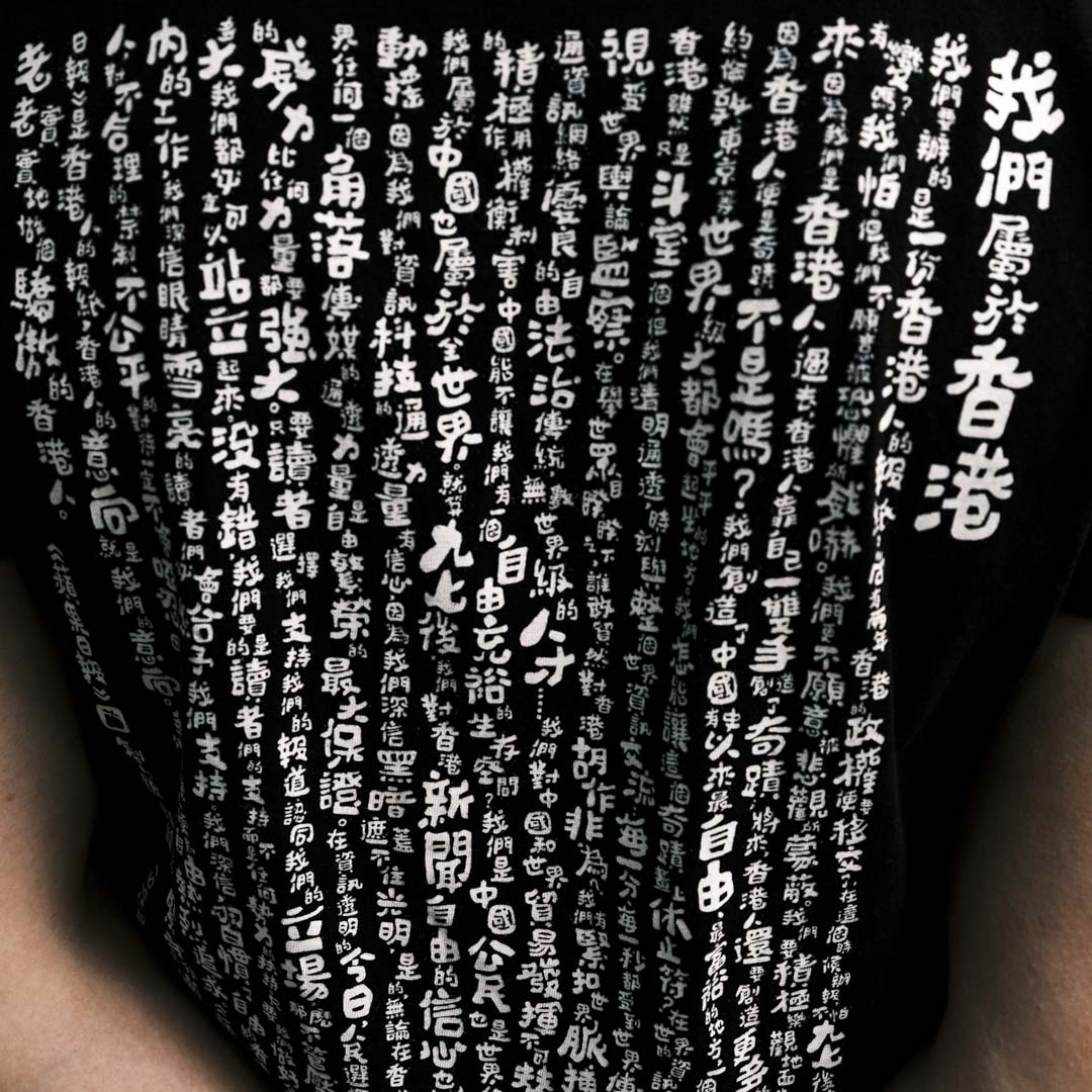 訪問當天,鄭子聰(化名)穿着印有《蘋果日報》1995年創刊社論的上衣。