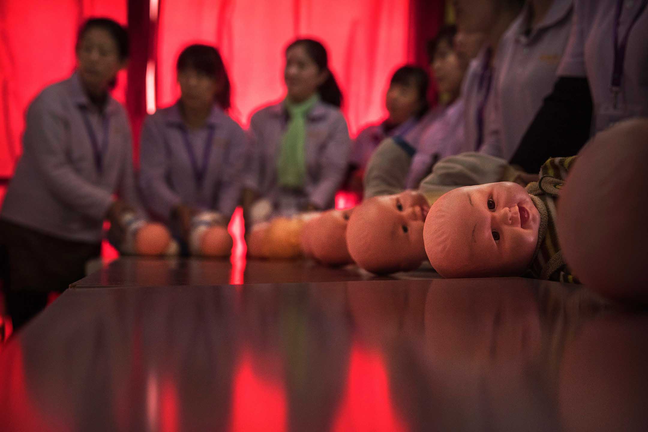 2016年10月28日,北京,中國婦女訓練成爲合格的保姆,桌子上放著塑料嬰兒。