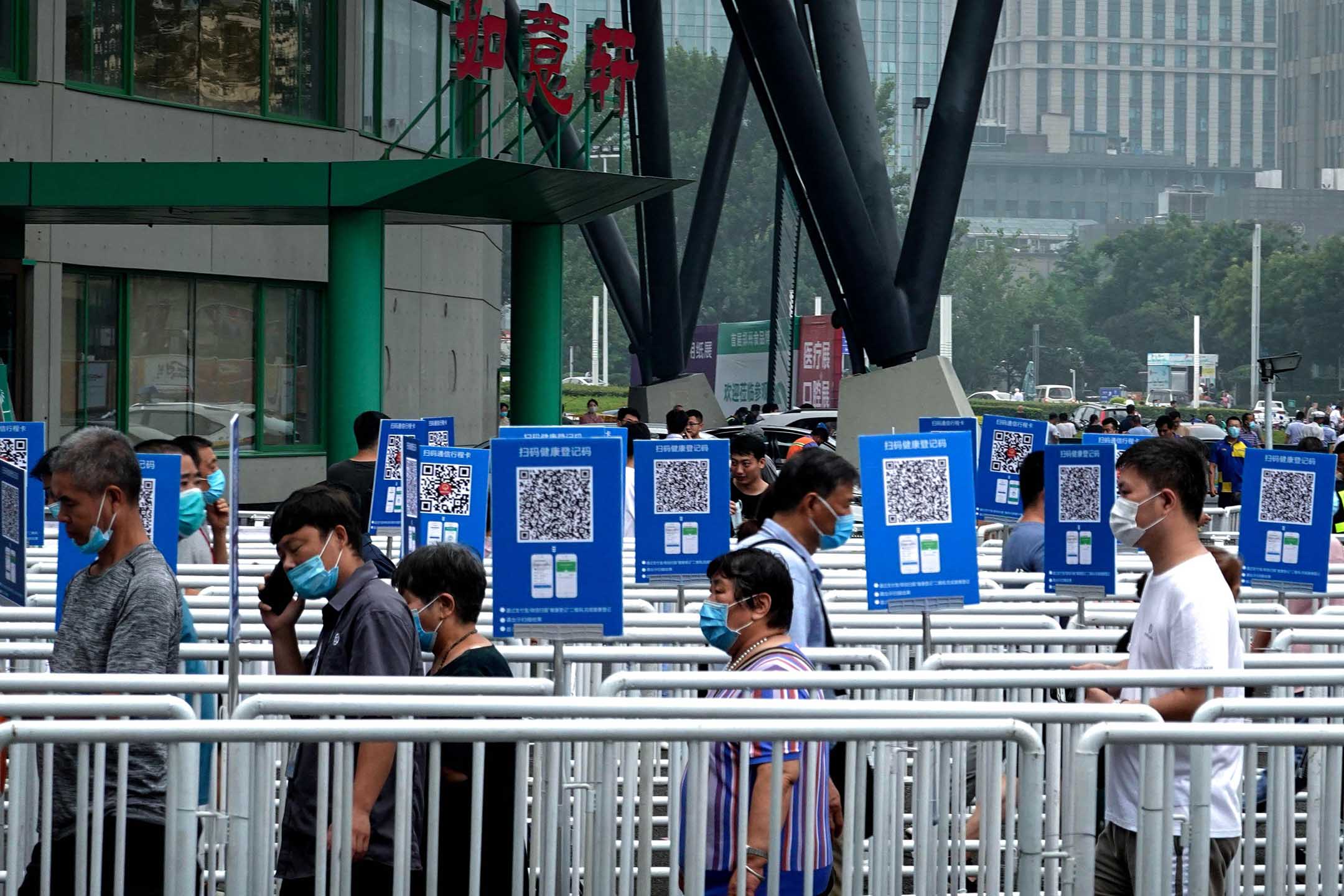 2020年8月5日,郑州,郑州食品博览会上,戴著口罩的人们排队接受体温检测。