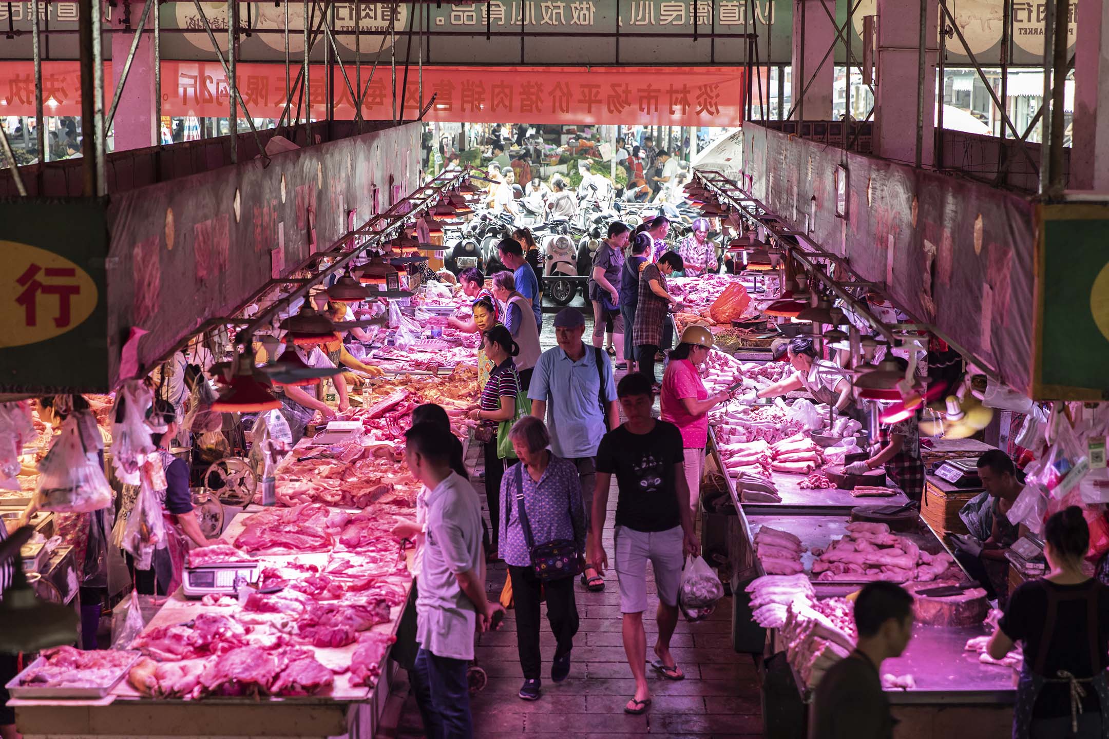 2019年9月17日,顾客走过广西省南宁市市场的猪肉摊位。