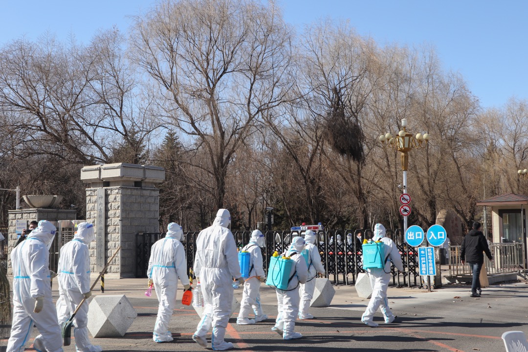 2022年3月11日,中国吉林,穿保护衣的工作人员到吉林农业科技学院进行消毒工作。