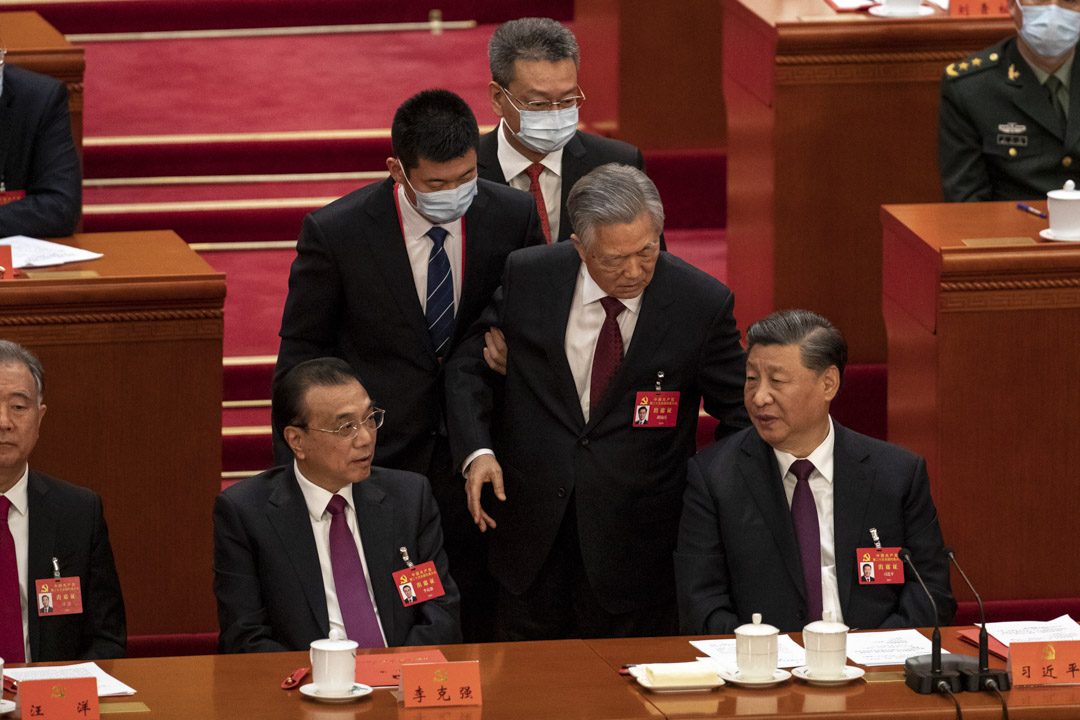 2022年10月22日，中國北京人民大會堂，中共前總書記胡錦濤在中國共產黨第二十次全國代表大會閉幕會議離場，並與中國國家主席習近平講話。圖：Bloomberg via Getty Images