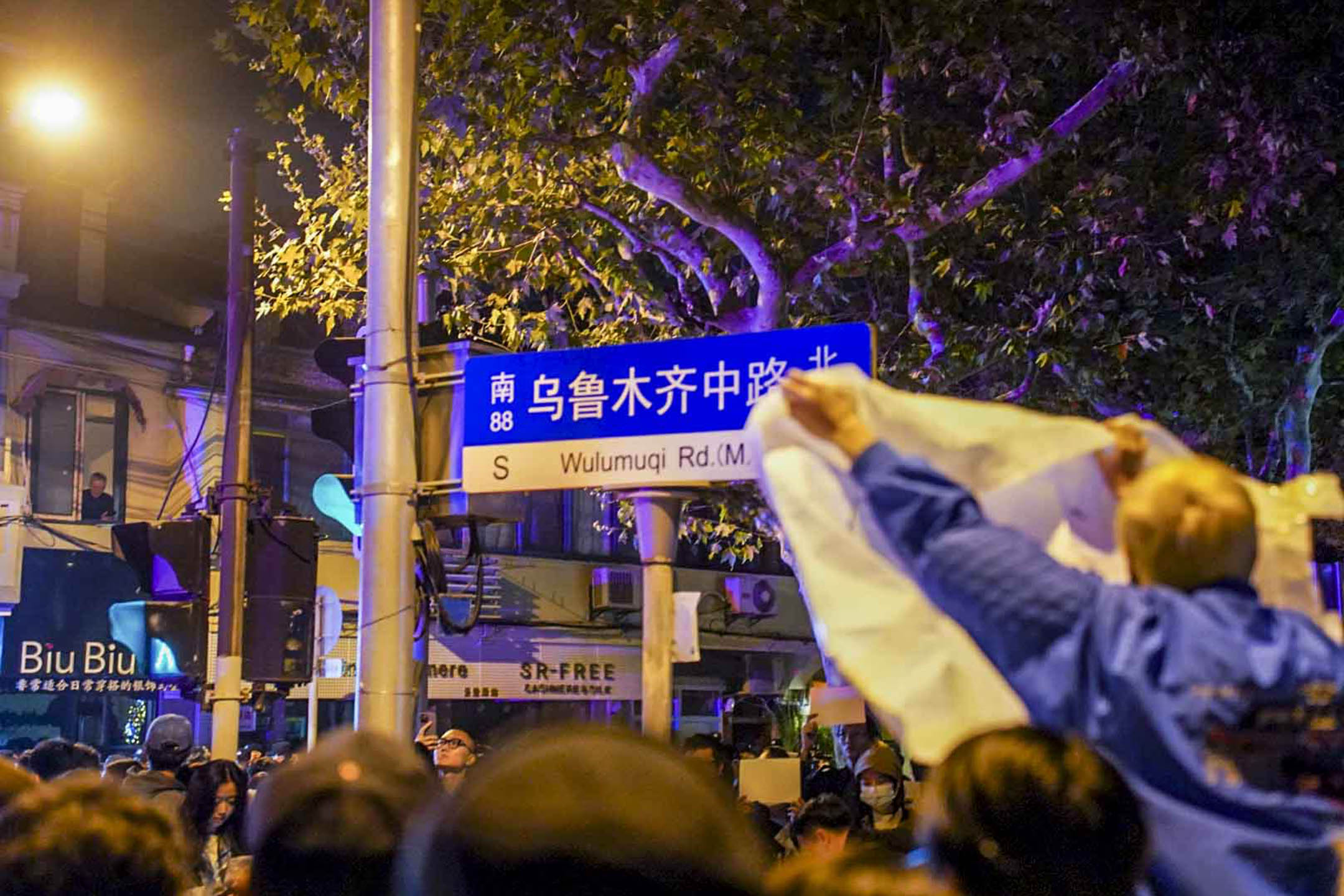 2022年11月26日深夜,上海烏魯木齊中路聚集大量市民,悼念11.24烏魯木齊火災10位逝者。