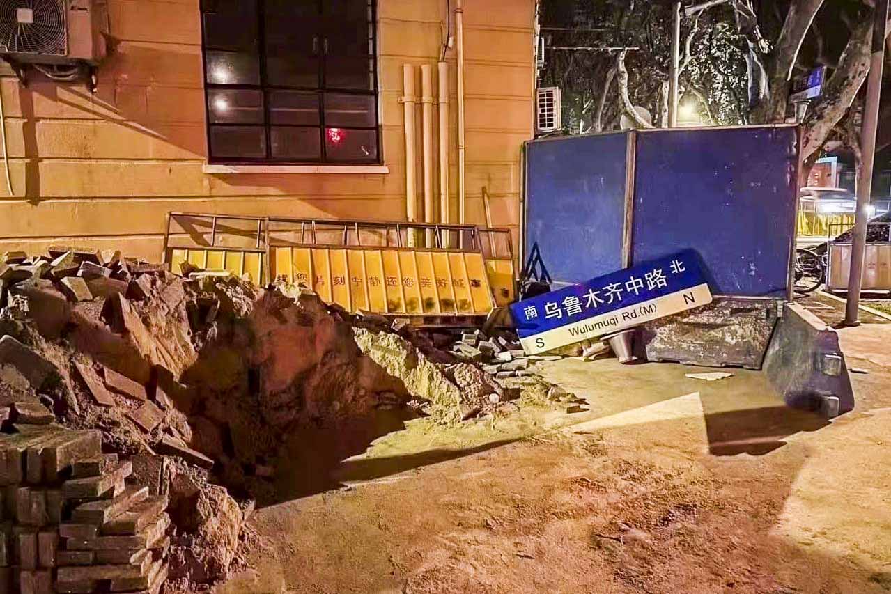 2022年11月27日,曾聚集大量悼念市民的上海烏魯木齊中路,路牌被拆掉放在地上。