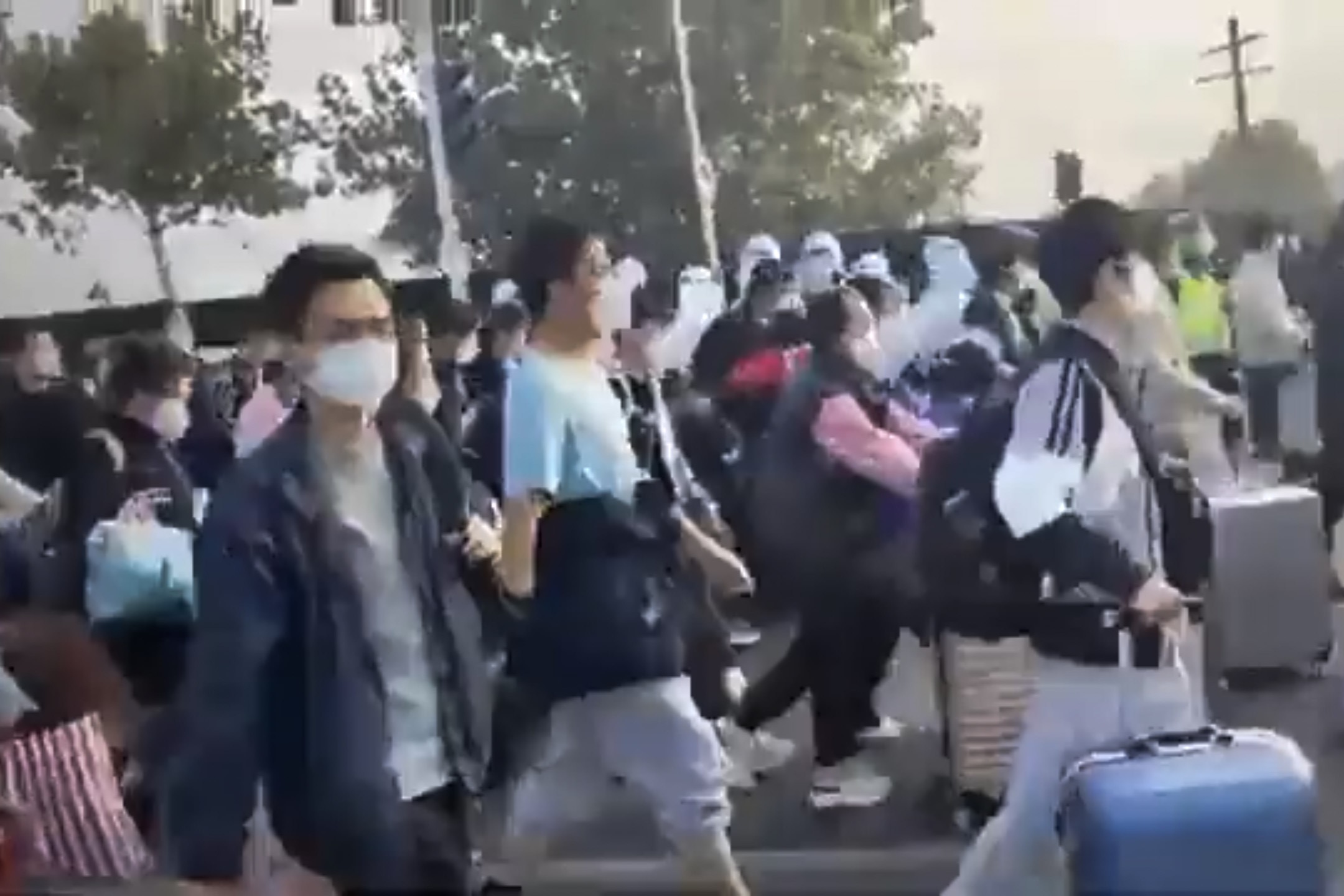 中國河南鄭州,大批富士康員工在防疫人員的安排下前往乘坐穿梭巴士離開廠區。