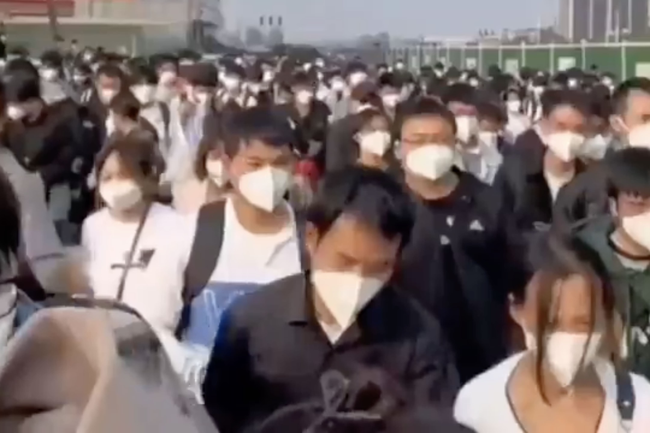 中國河南鄭州,大批富士康員工在防疫人員的安排下前往乘坐穿梭巴士離開廠區。