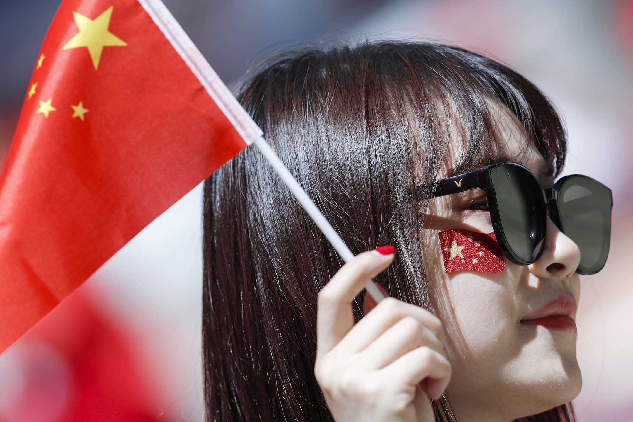 2018年6月20日,俄羅斯,一名婦女在2018世界杯葡萄牙和摩洛哥的比賽前,拿著中國國旗。