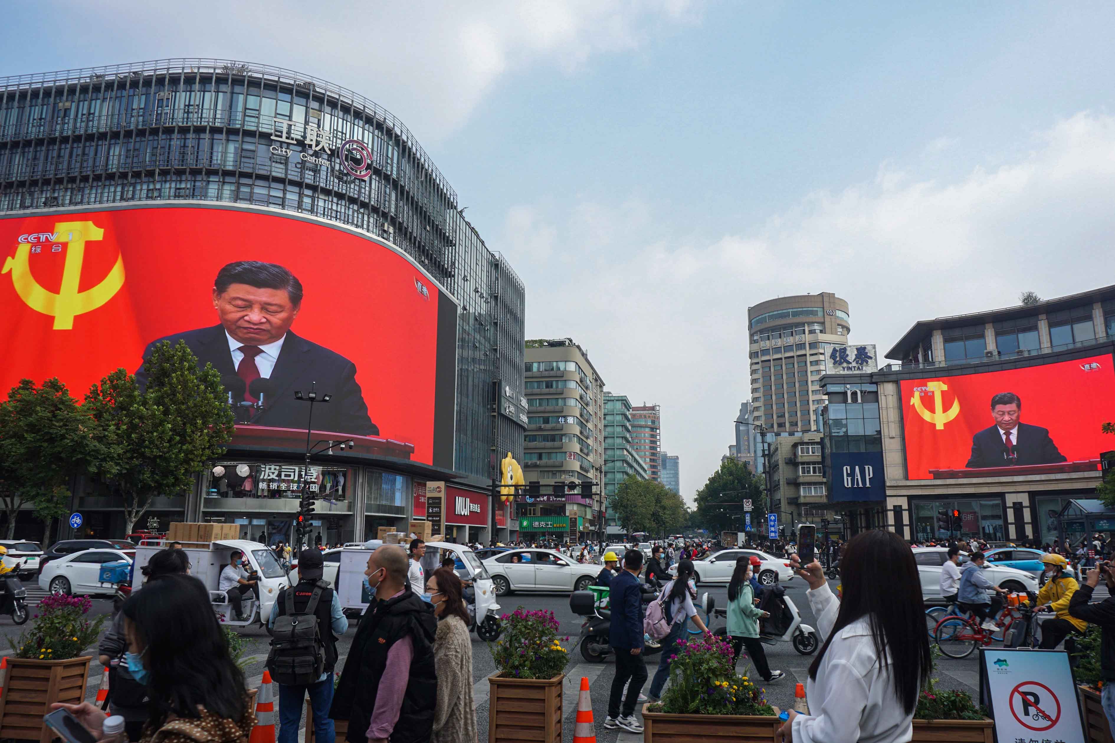 2022年10月23日，杭州，人們經過一個十字路口，巨大的屏幕播放習近平在共產黨第二十次全國代表大會閉幕式上的講話。