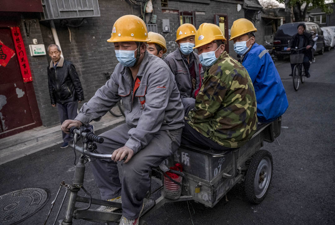 2021年4月14日,中国北京的建筑工人骑著三轮车在街上行走。