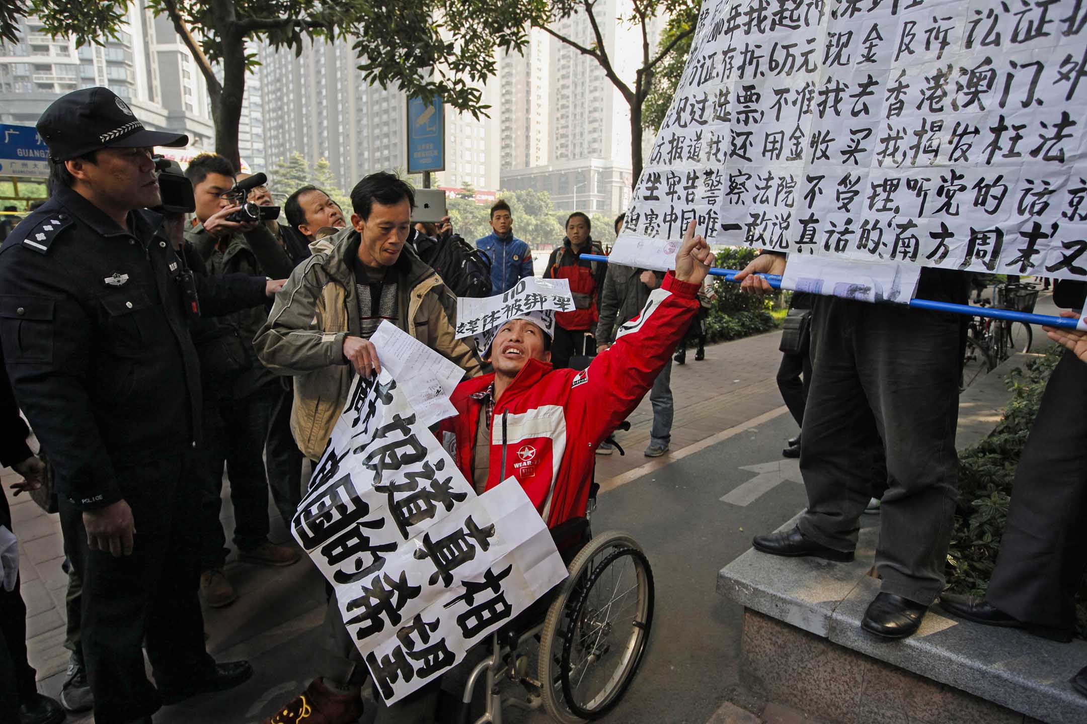 2013年1月10日,廣州,一名坐在輪椅上的《南方周末》支持者,在《南方周末》辦公室附近抗議被警察帶走。