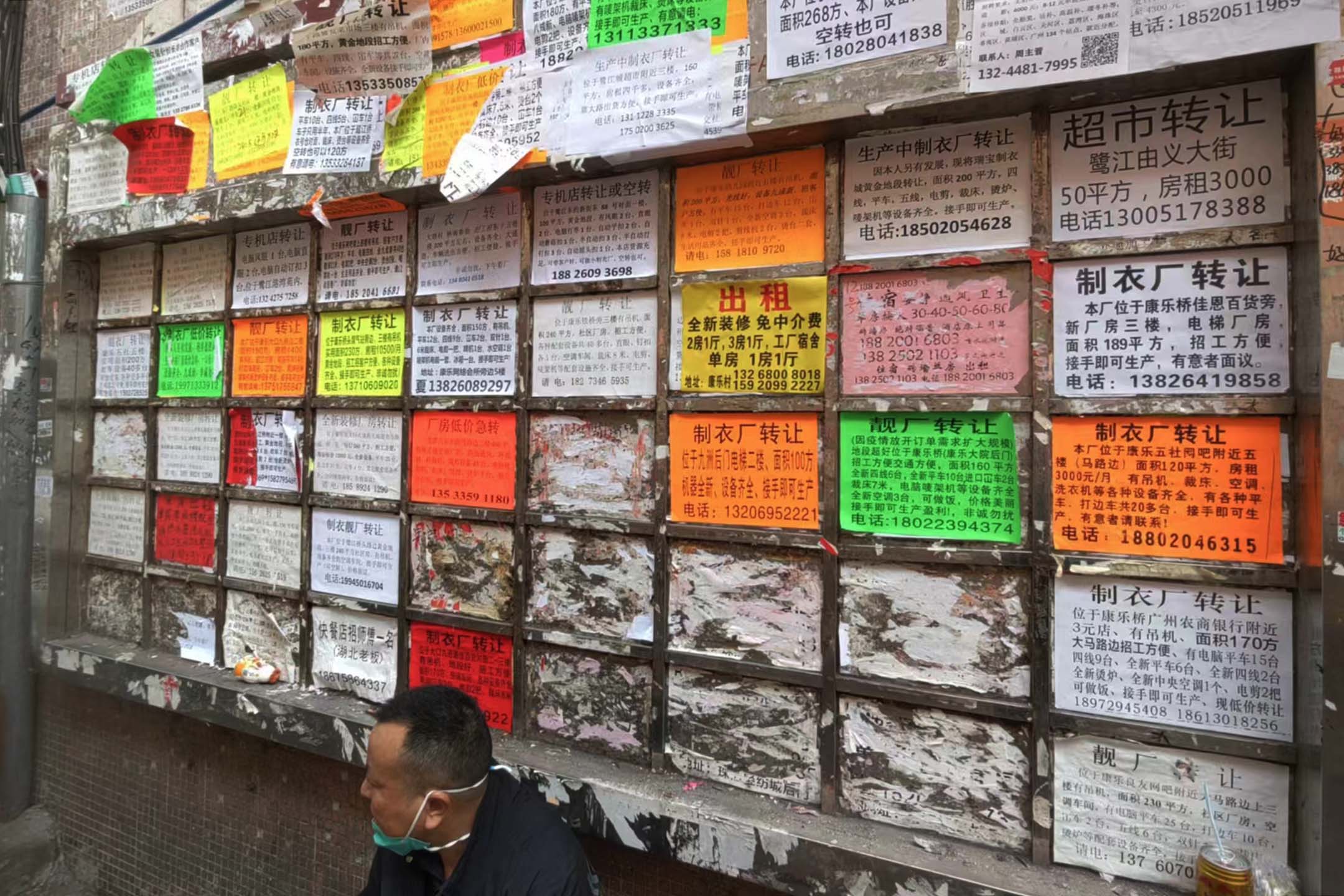 康樂村一處張貼板上貼著大量製衣廠轉讓的小廣告。